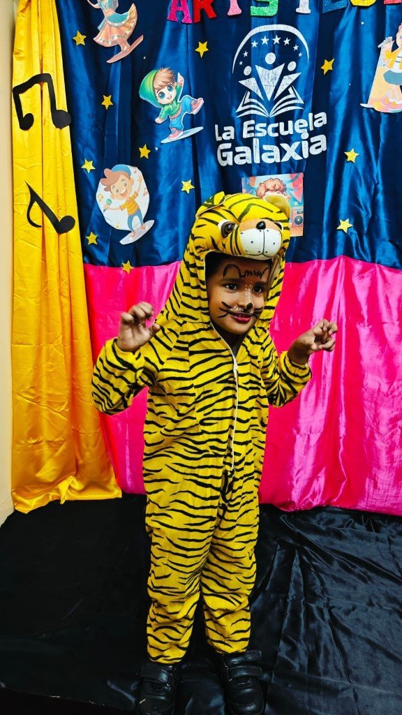 Child in tiger costume on stage at La Escuela Galaxia