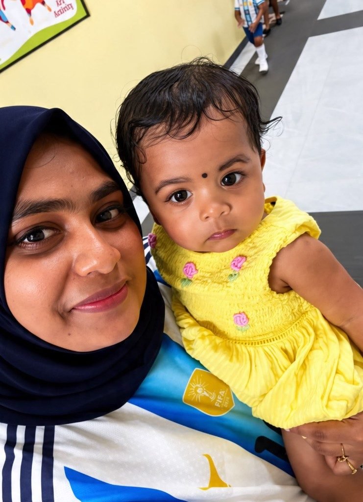 Caring educator holding an infant with gentle individual attention at Galaxy Infant School