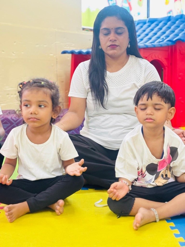 Teacher guiding toddlers in seated mindfulness
