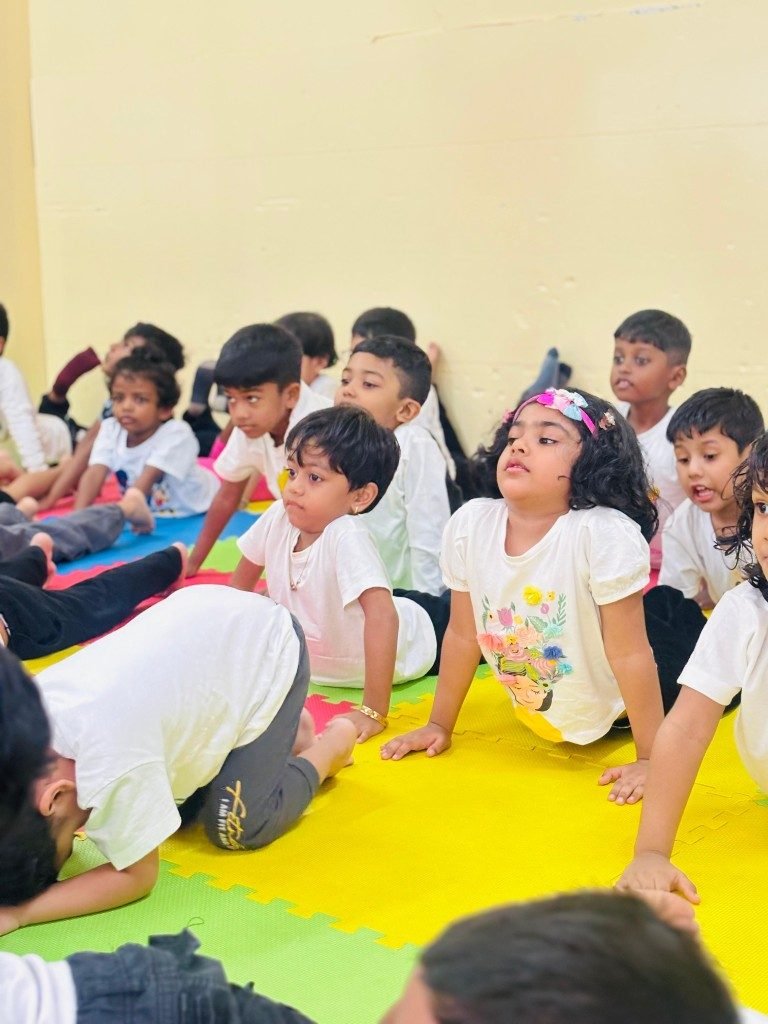 Toddlers in cobra pose during yoga at Tiny Explorers Club