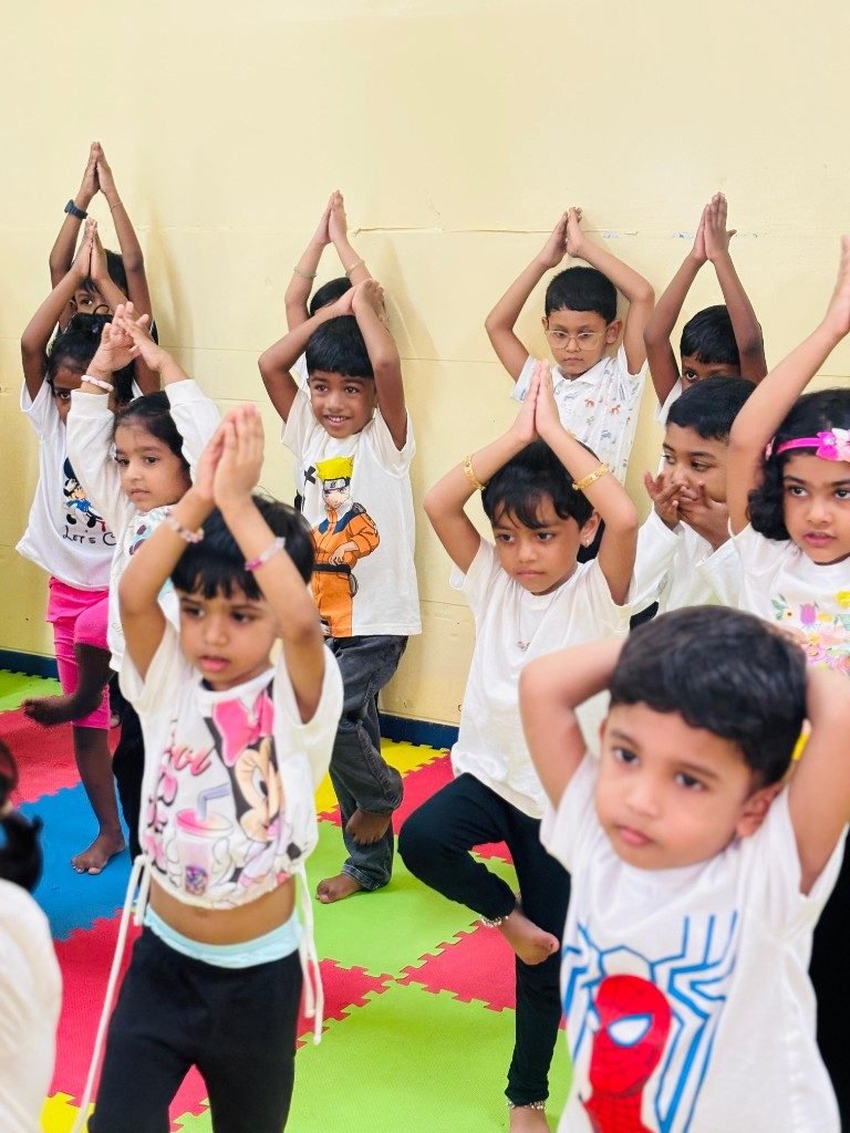 Children practicing tree pose yoga at Galaxy Infant School